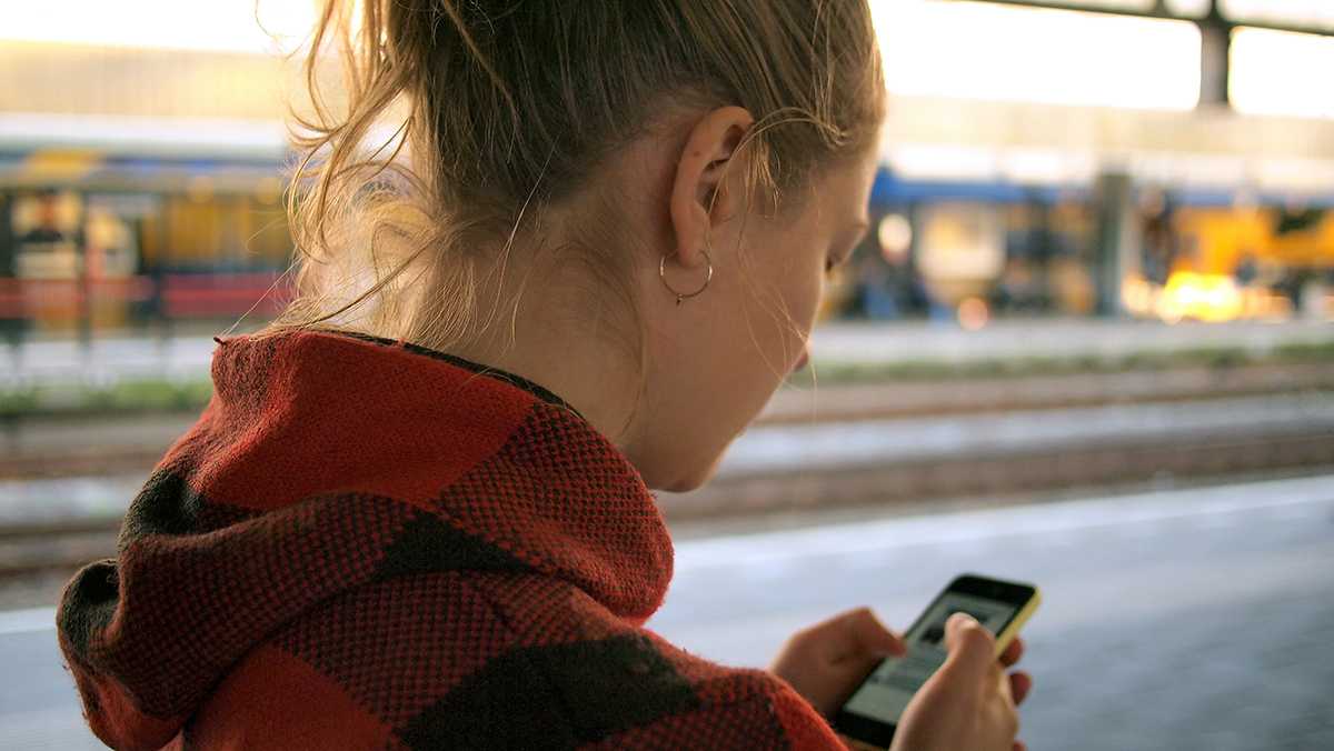 A girl scheduling a cab on her phone